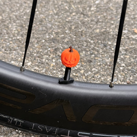 Pumpkin valve cap on a road bike wheel